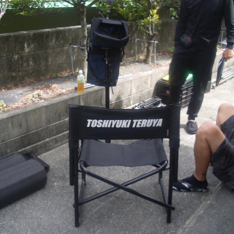 「TOSHIYUKI TERUYA」と名前が入ったディレクターズチェア