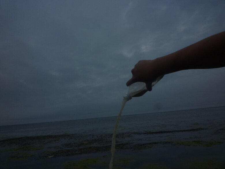 2010年6月に撮った「写心」。47都道府県ひとり旅を達成後、旅の間1年間持ち歩いてきた沖縄の海水を北海道の海に入れるところ