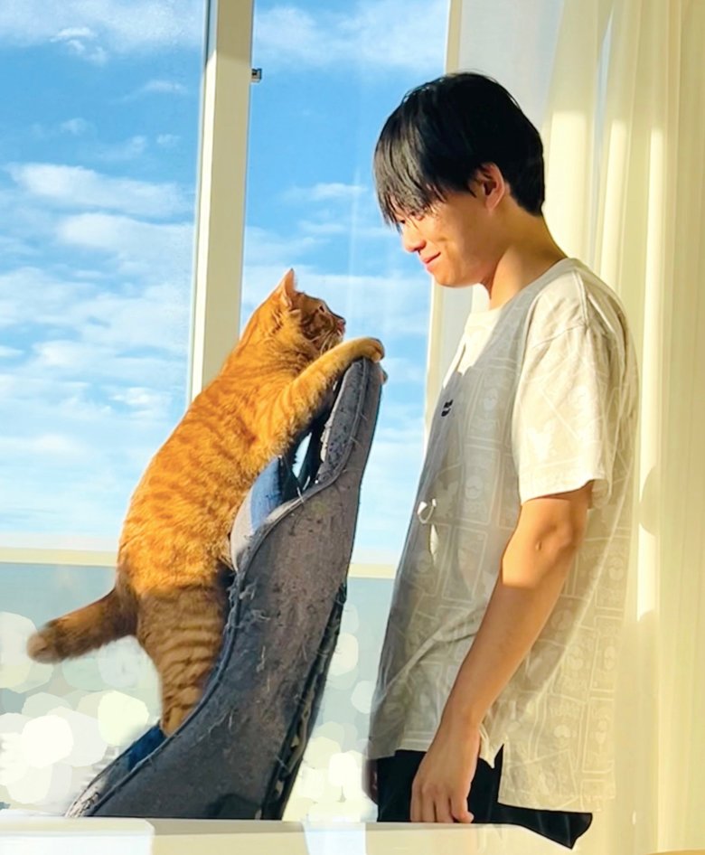 仕事が休みの日曜日、元保護猫のリドくんと「いちゃいちゃ」。友人が撮影した一枚。松丸さんのTwitterより