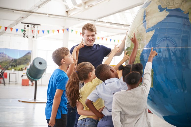 School kids pointing at a giant globe at a science centre