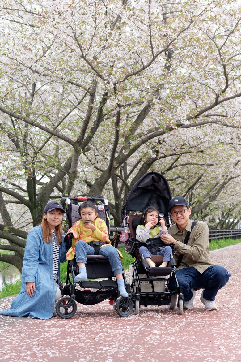 桜の時期に家族4人で。明愛さん（手前右）と蒼依さん（手前左）は子ども用の車いすに乗って移動