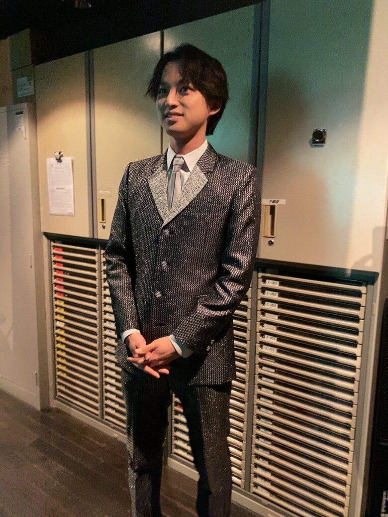 撮影を前に光沢のあるスーツに身を包んだ青山さん