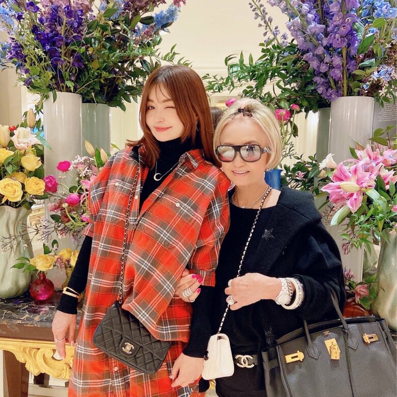 ホテルのロビーに飾られたお花を背景に理沙さんと母と娘の2ショット