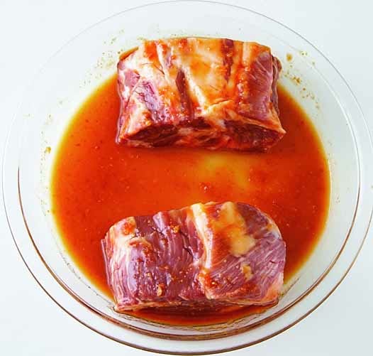 豚肉は室温に20分おいてから、包丁の先で全面をつついて火の通りをよくし、2つに切る。直径25㎝の耐熱皿に豚肉を置いて、混ぜ合わせたAをかけて全体にからめる。豚肉を両端に並べて、ラップなしで600Wの電子レンジで15分加熱する。