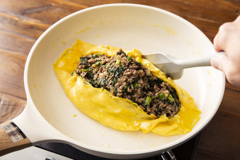 ②のフライパンにバターを中火で熱し、③を入れてゴムベラなどで大きく混ぜる。半熟状になったら火を止めて中央に②をのせ、卵の両端を折って具にかぶせる。フライパンの向こう側に寄せ、フライパンごとひっくり返して器に盛り、オムレツの形に整えてケチャップをかける。