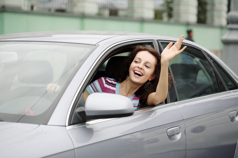 Happy Young Woman Driving Car