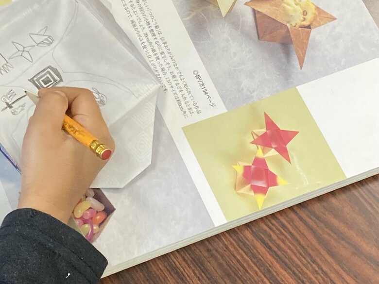 熱心に折り紙の工程を描く子どもも