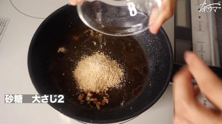 【作り方18】鶏胸肉を熱したフライパンにみじん切りしたにんにくを入れ、砂糖大さじ2を入れる