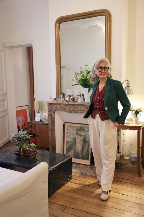 自宅のリビングにて。真っ赤なブラウスは40年前のケンゾー。グリーンの麻のジャケットはラルフローレンのヴィンテージ