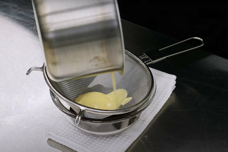 【作り方11】チョコレートを入れたボウルに火から下ろした生地を濾しながら流す