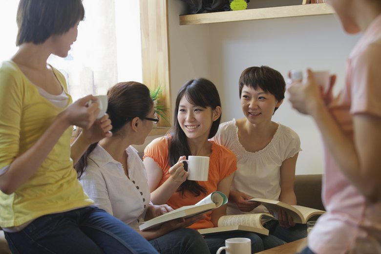 Five friends sitting in coffee shop, reading, discussing