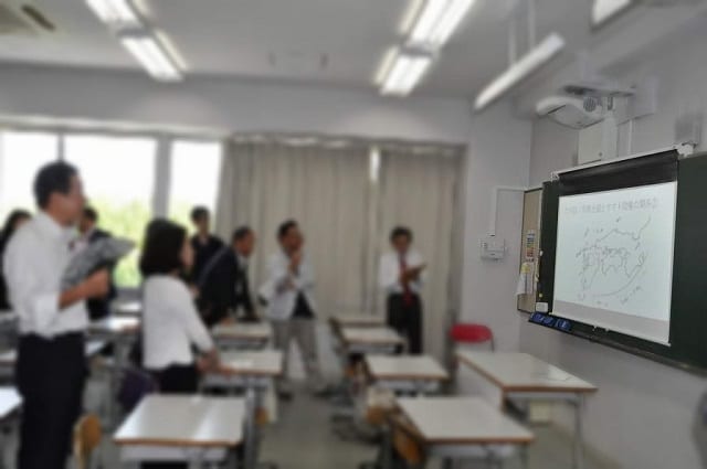 母校を訪れ、先生から模擬授業を受ける同窓生たち