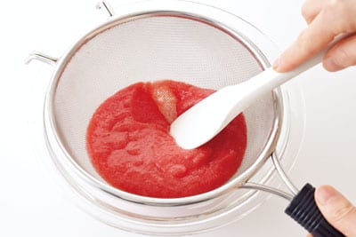 フルーツトマトはざく切りにしてミキサーにかけてからざるでこしてなめらかにし、レモン汁を混ぜ合わせる。