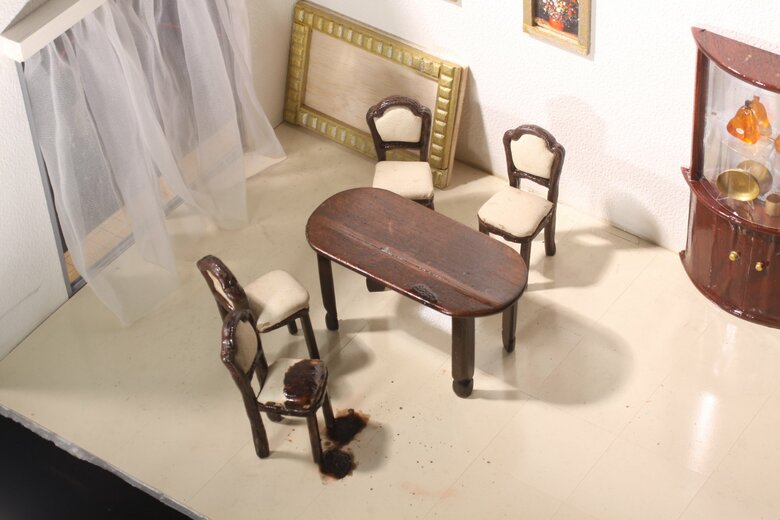 椅子に座ったまま亡くなったであろう現場を再現したミニチュア