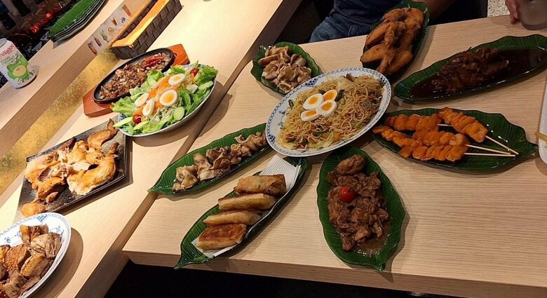 中央に置かれたパンシットカントン（焼きそば）をはじめとした、日本風にアレンジした高橋ペンさんのフィリピン料理