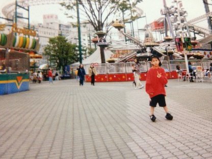 遊園地でピースサインもどこか寂しそう