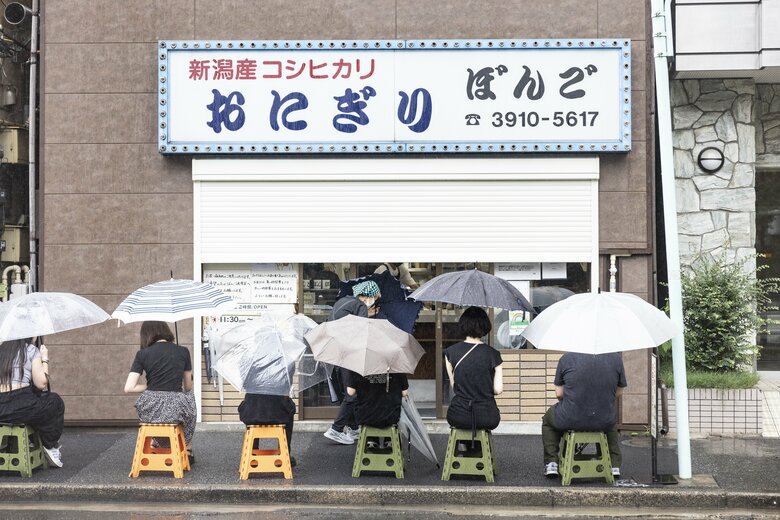 平日の雨が降るなか、開店前から行列ができる
