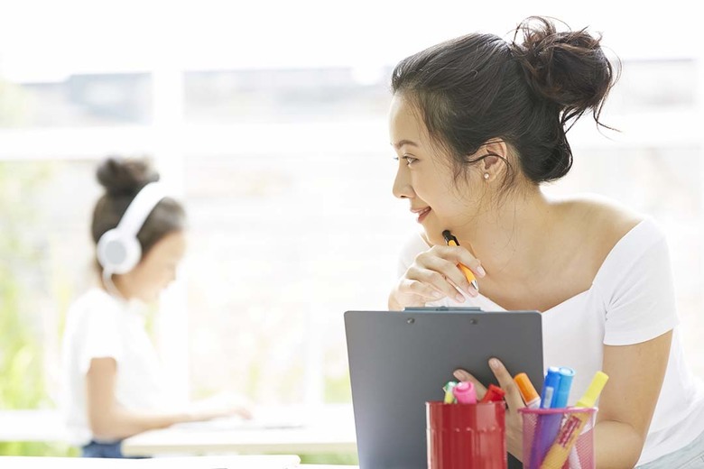 在宅ワークをしながら子どもを見守る女性