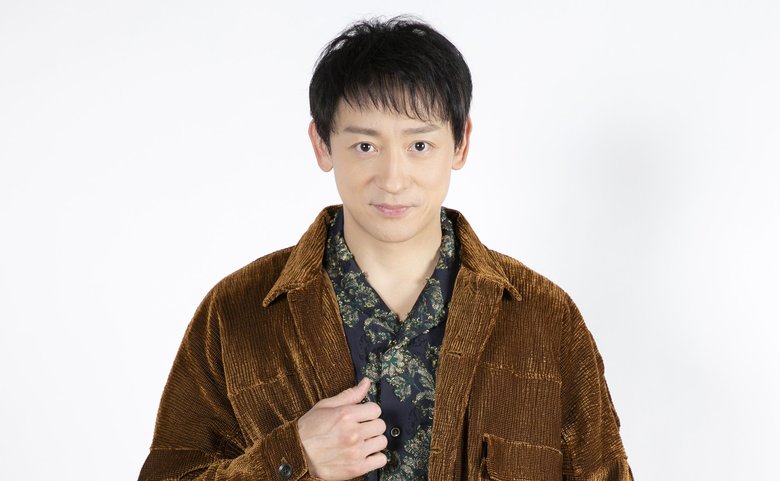 ジャケットに手を添えキリッとした表情の山本さん