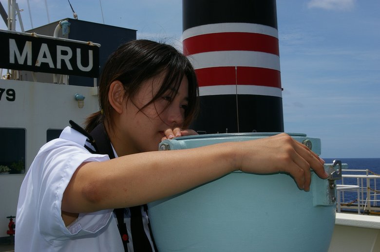 三等航海士の頃、後輩が撮影してくれたという1枚。船の場所を計測するため、ジャイロコンパスで灯台の方位を図っているところ