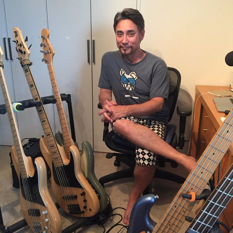 愛用のベースギターと共に。自宅にて