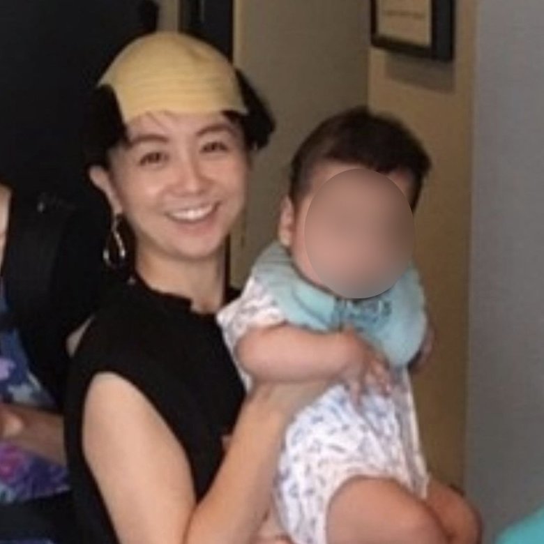 かぶり物をかぶり、子どもを抱く福田さん