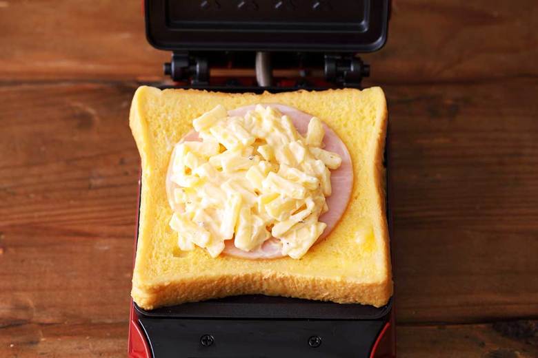 ホットサンドメーカーに②のパンを1枚のせ、ハム、①の順にのせる。もう1枚のパンをのせたらカバーを閉じて焼く。