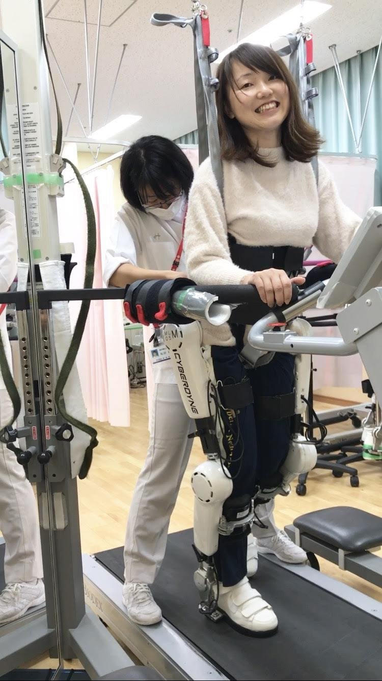 ロボットスーツを着用してリハビリを行う小澤さん