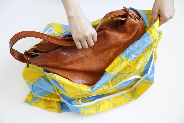 ▲「撥水加工レインバッグ」に、バッグを入れます