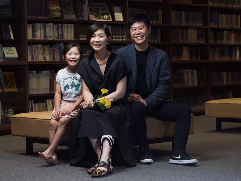下肢装具を付け、自身が作った靴を履く布施田祥子さん（中央）。家族と一緒に