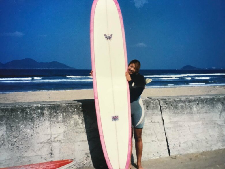 ピンクのロングボードがかわいい！趣味のサーフィンを楽しんでいた25歳ごろの梅津さん