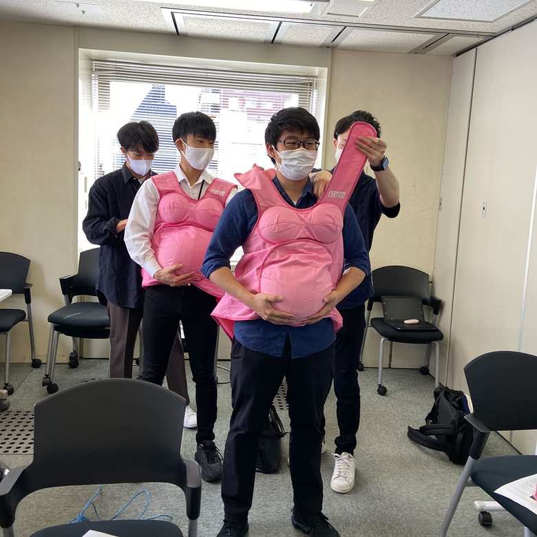 「育児研修」で妊婦体験をする男性社員たち