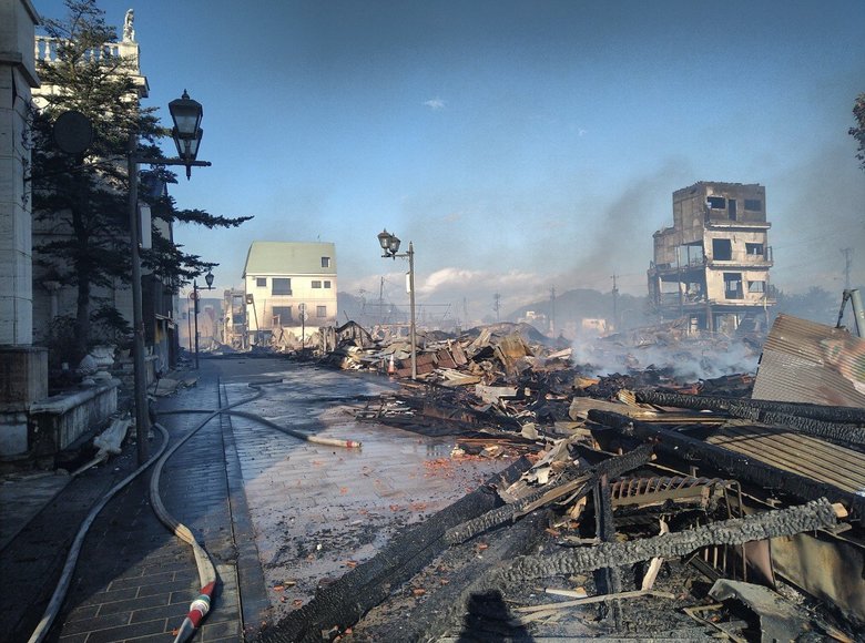 震災翌日の朝市通りの様子。緑の屋根のビルが小西さんの店