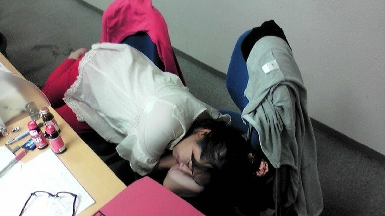 司法試験受験の勉強時には疲れて眠りこむ平松さん、机には栄養ドリンクが並ぶ