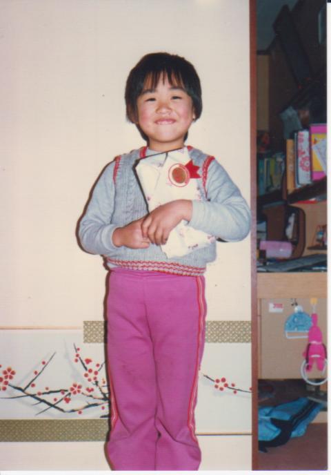 子どものころ、プレゼントをもらって笑顔の山崎さん