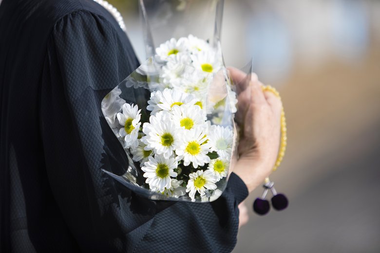 A funeral and visit to a grave of Japan. The woman of the senior worships the ancestral soul in a black mourning dress. I hold white chrysanthemum bunch and beads in a hand.