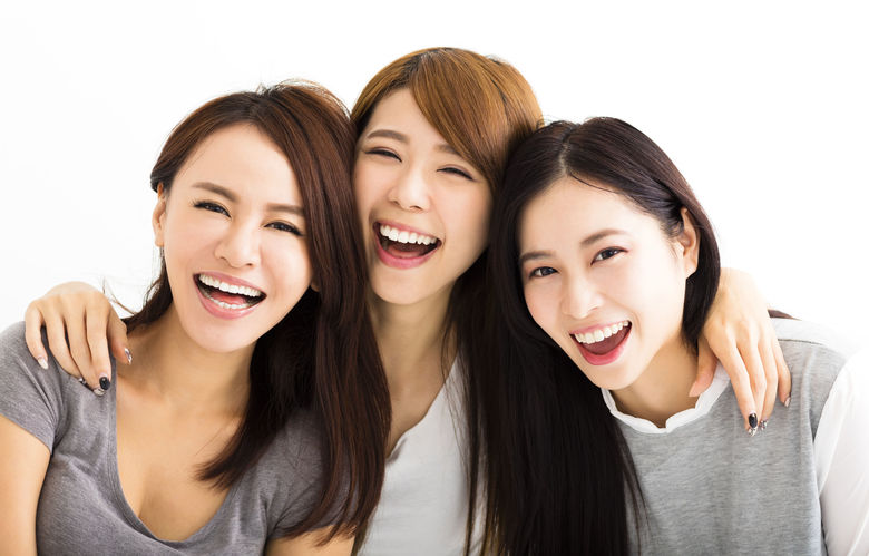 47920500 - closeup happy young women faces looking at camera