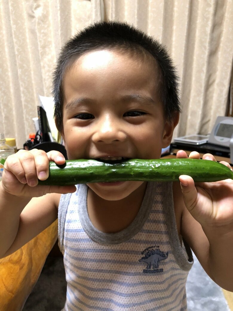 ▲満面の笑みでキュウリを丸かじりする息子。