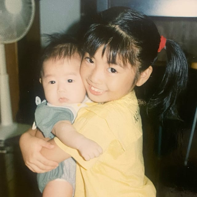 弟を抱っこする幼少期の齊藤さん（写真右）