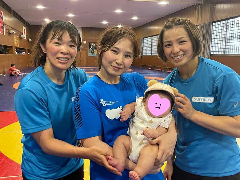 今年8月の合宿での1枚。金城さんのお子さんを抱くのは土性沙羅選手。右は妹の友香子さん