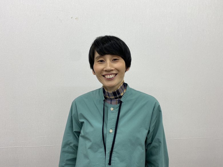 休憩時間に一枚。グリーンのシャツを爽やかに着ている箕輪さん