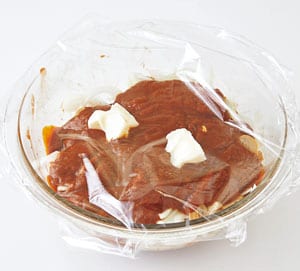 直径26cmの耐熱ボウルに牛肉を入れ、Aをもみこみ、室温に15分おく。その上に、薄切りにした玉ねぎ、汁けをきったマッシュルームを順に広げてのせ、ドミグラスソースをかける。バターをのせて、ふんわりラップをして、600Ｗの電子レンジで20分加熱する。