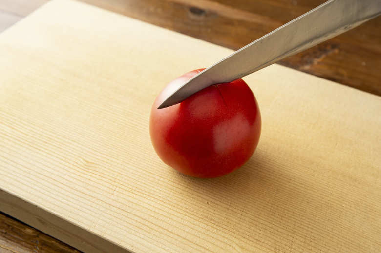 トマトはヘタを取り、十字に切り込みを入れる。とうもろこしは縦に置き、包丁を上から下に動かして削ぎ取るようにして芯から実をはずす。ベーコンは1cm角に切る。