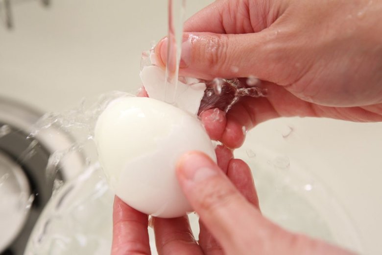流水にさらしながら卵の殻を剥いているところ