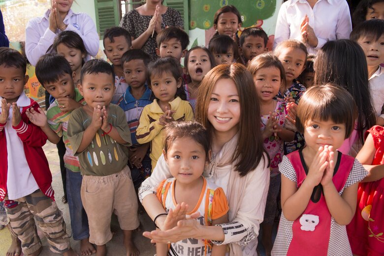 カンボジアの子どもたちに囲まれて満面の笑みの倉木さん