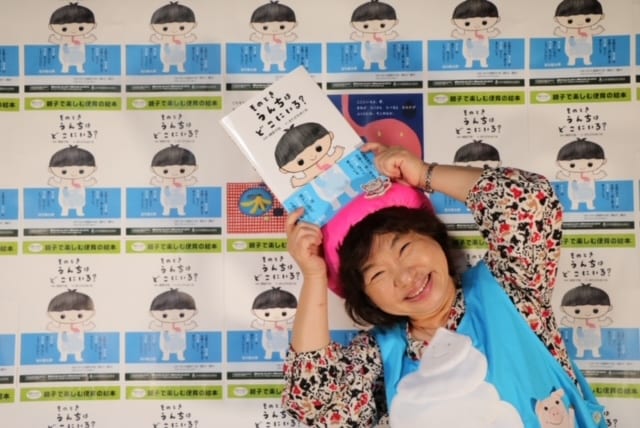 自著の絵本を手にポーズをとる榊原さん