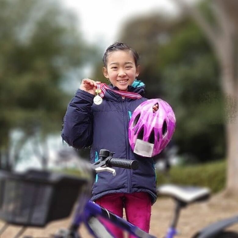 2022年にトライアスロンの大会に出場し、無事完走メダルを手にする村山さん