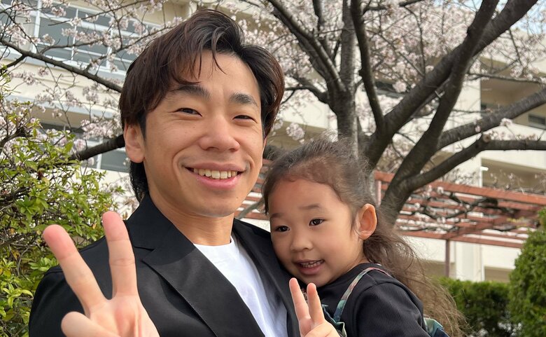 桜の下で長女を抱っこする織田信成さん