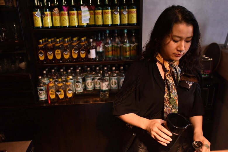 ボトルキープされたお酒が並ぶカウンターで、慣れた手つきでお酒を作る坂根さん