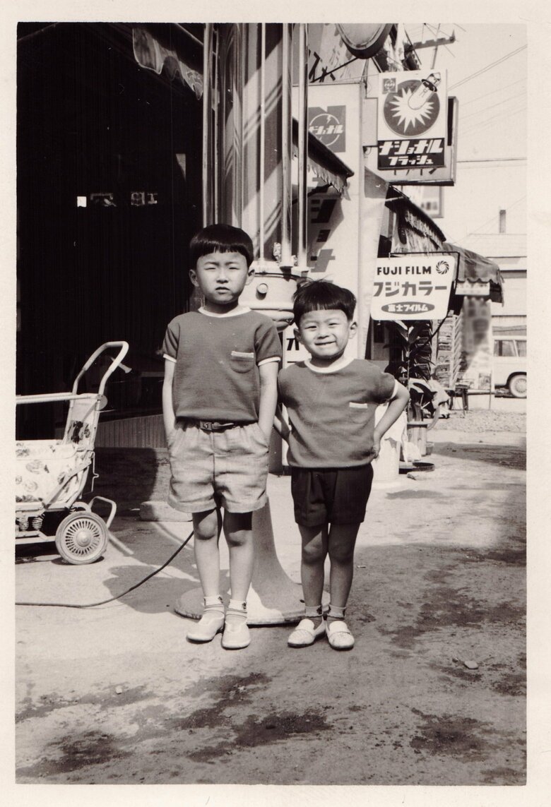 お兄さんと一緒の少年時代の山田さん（右）